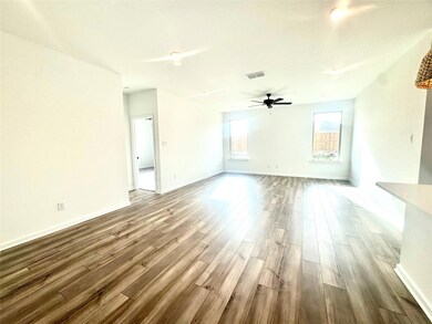 Unfurnished living room featuring a ceiling fan, b
