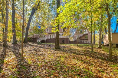 Back of house features oversized deck.  Note separate garage, shop, and storage room above garage.  Also features 2 separate storage buildings.