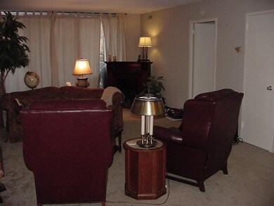 Spacious living room  with balcony behind drapes.