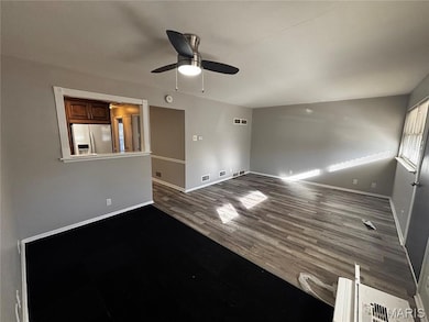 Unfurnished room featuring dark wood-style flooring and a ceiling fan
