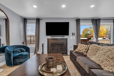 Living room with a fireplace, wood finished floors, and recessed lighting