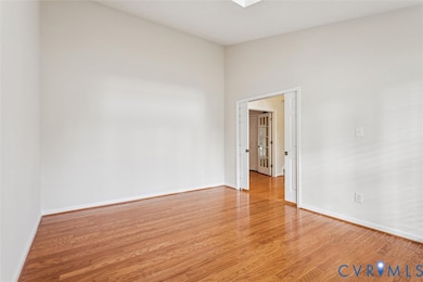 Spare room featuring light wood-style flooring and baseboards