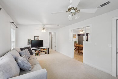 Carpeted living room featuring ceiling fan