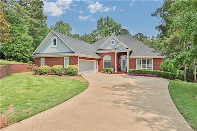 Neoclassical home with brick siding, driveway, a garage, and a front yard
