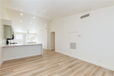 Unfurnished living room featuring vaulted ceiling,