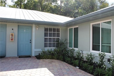 View of exterior entry featuring stucco siding, a standing seam roof, and a metal roof