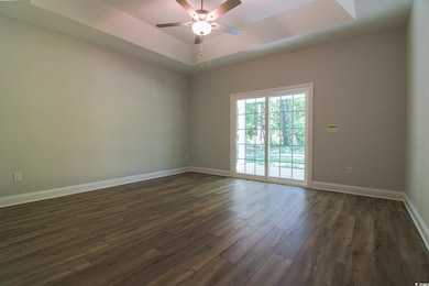 Empty room featuring a raised ceiling, baseboards,
