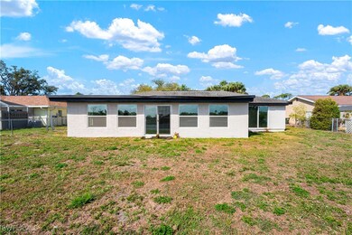 Rear view of house featuring fence, stucco siding,
