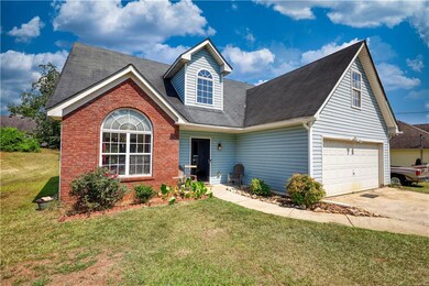 View of front facade with concrete driveway, a front yard, brick siding, a shingled roof, and an attached garage