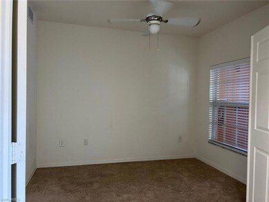Carpeted spare room featuring ceiling fan