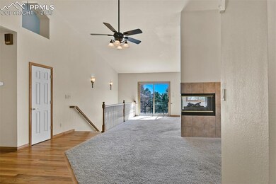 Living room with vaulted ceiling, hardwood floors, and ceiling fan.