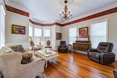 Living room featuring a chandelier, wainscoting, w