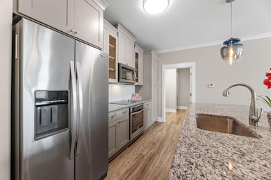 Kitchen with light wood-type flooring, glass inser