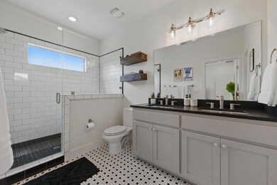 Full bathroom featuring double vanity, toilet, a 