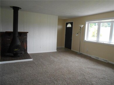 Nice size living room with new carpet, wood burner