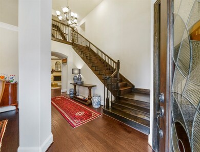 Through the beautiful front door is this breathtaking foyer! Boasting high ceilings, stunning chandelier, gorgeous wood floors, and an incredible staircase with elegant wrought iron spindles!