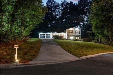 Tri-level home featuring driveway, an attached garage, and a front lawn