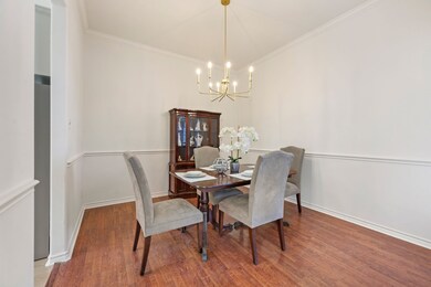 Dining room featuring wood finished floors, ornamental molding, and a chandelier
