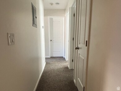 Hall featuring dark colored carpet