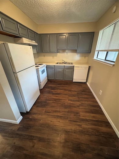 Kitchen featuring a sink, gray cabinetry, dishwas