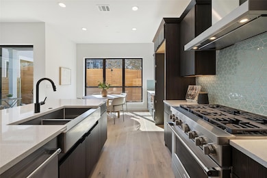 Kitchen with light wood-type flooring, stainless 