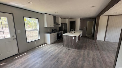 Kitchen featuring electric range, white cabinets, 