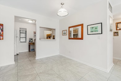 Unfurnished room with light tile patterned floors and baseboards