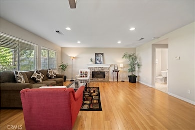 Casual Room showing stacked stone fireplace and wood floors.