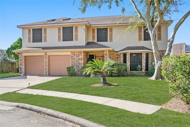 This photo showcases a two-story house with a brick and siding exterior, featuring a two-car garage. The front yard is well-maintained with lush grass and a few trees, providing a welcoming curb appeal.