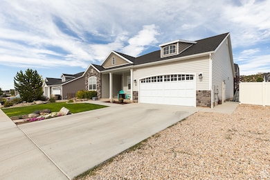 View of front of house with stone siding, an attached garage, and driveway
