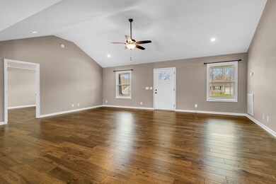 A sleek ceiling fan gracefully spins overhead, complementing the recessed lighting that illuminates the space and accentuates the beauty of the shiny, dark hardwood floors.  418 N Ballard Rd  Manchester, TN 37355