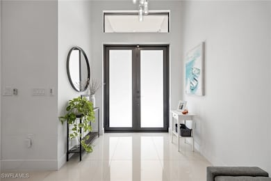 Foyer with tile patterned floors, french doors, an