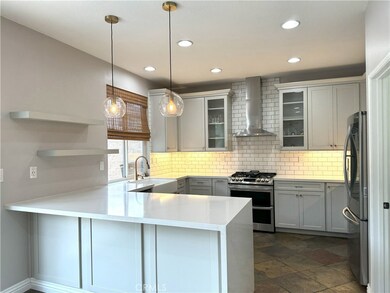 Completely Remodeled Kitchen with Breakfast Bar, Custom Cabinets, Quartz countertops with waterfall feature, custom backsplash, and high end stainless steel appliances