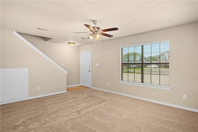 Unfurnished living room with light colored carpet and ceiling fan