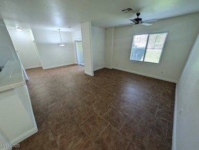 Spare room featuring a ceiling fan and baseboards