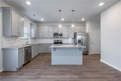 Kitchen featuring wood-type flooring, appliances w