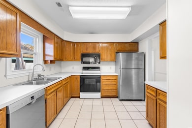 Kitchen with light tile patterned flooring, a text