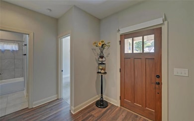 Foyer featuring dark wood-style floors and baseboards