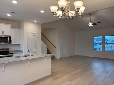 Kitchen with pendant lighting, white cabinets, a k