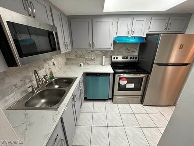 Kitchen featuring gray cabinetry, sink, backsplash