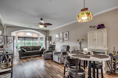 Dining room with crown molding, a ceiling fan, and wood finished floors