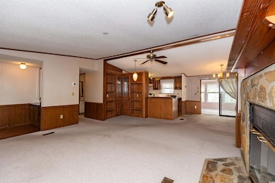 Unfurnished living room with a stone fireplace, wo