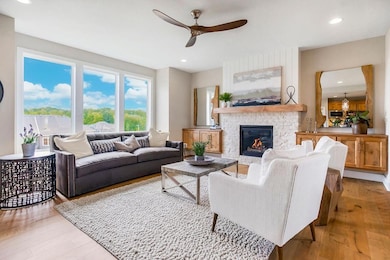 Living area featuring ceiling fan, wood finished floors, a fireplace, and recessed lighting