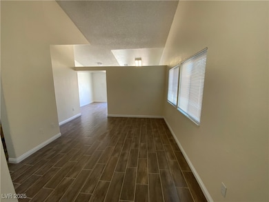 Spare room with a textured ceiling, dark wood-styl