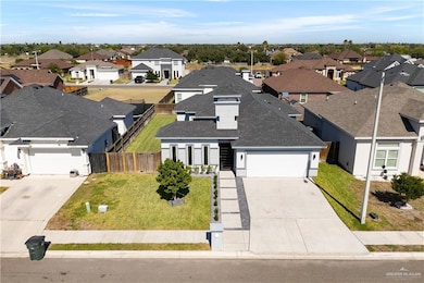 View of front of house featuring roof with shingles, driveway, an attached garage, and a residential view
