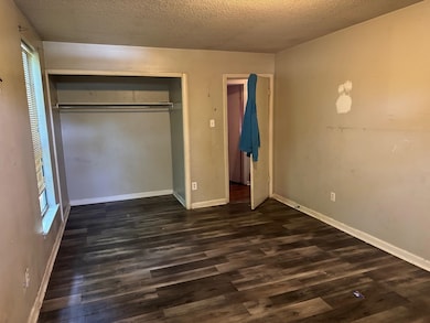 Unfurnished bedroom featuring dark wood finished f