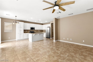 Kitchen featuring a ceiling fan, open floor plan,