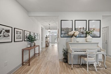 Hallway with wood finished floors and a chandelier