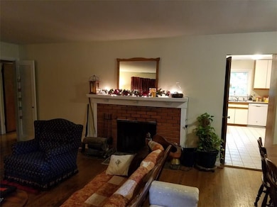 VIEW OF LIVING ROOM FIREPLACE AND KITCHEN ENTRANCE