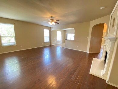 Unfurnished living room with ceiling fan, a healthy amount of sunlight, and dark hardwood / wood-style flooring